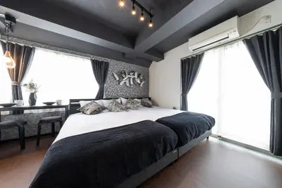 a bedroom with a large bed and large windows at Shinjuku Homely Stay in Tokyo