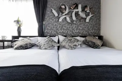 a bedroom with two beds with shoes on the wall at Shinjuku Homely Stay in Tokyo