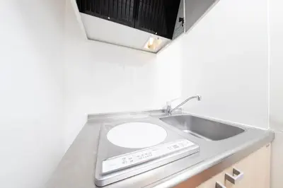 a kitchen counter with a sink and a microwave at Shinjuku Homely Stay in Tokyo