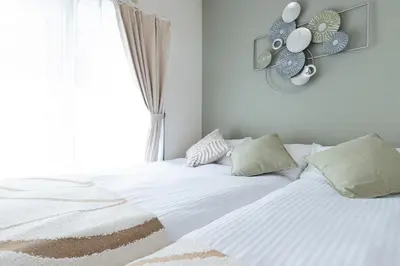 a bedroom with a white bed with a window at Shinjuku Homely Stay in Tokyo