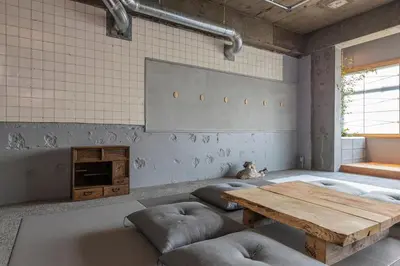 a room with a wooden table and some pillows at \u30b7\u30ce\u30f3\u8535\u524d CINON Kuramae in Tokyo