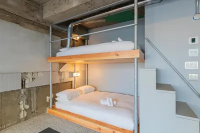two bunk beds in a room with a staircase at \u30b7\u30ce\u30f3\u8535\u524d CINON Kuramae in Tokyo