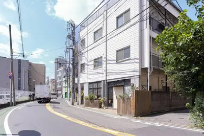a truck driving down a street next to a building at Aimer202 AI22 in Tokyo