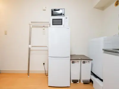 a white refrigerator with a microwave on top of it at Shinjuku,5min Walk to Higashi-Shinjuku sta & Shinjuku Sta,King Bed,ree Wi-Fi in Tokyo