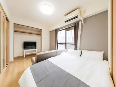 a bedroom with a white bed and a television at Shinjuku,5min Walk to Higashi-Shinjuku sta & Shinjuku Sta,King Bed,ree Wi-Fi in Tokyo