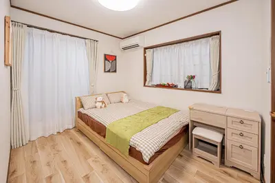 a bedroom with a bed and a desk and a window at Koiwa Station Entire Villa Two Generation House with 1BR Cozy Apartment and 4BR Spacious Home Easy JR Access to Asakusa Skytree Shinjuku Shibuya Ueno and Narita Haneda Airport in Tokyo
