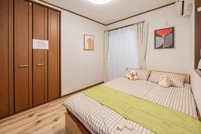 a bedroom with a bed with two teddy bears on it at Koiwa Station Entire Villa Two Generation House with 1BR Cozy Apartment and 4BR Spacious Home Easy JR Access to Asakusa Skytree Shinjuku Shibuya Ueno and Narita Haneda Airport in Tokyo