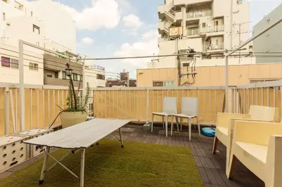 a balcony with a wooden bench and chairs on it at Minimalism HOTEL Asakusa in Tokyo