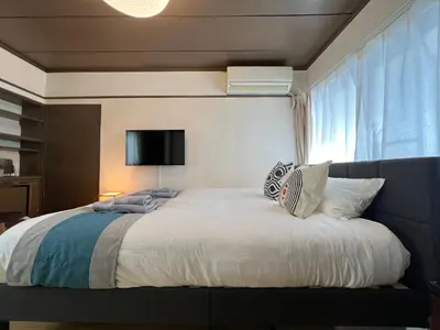 a bedroom with a large white bed with a window at nestay suite tokyo Takadanobaba in Tokyo