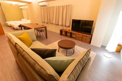 a living room with a couch and a television at NEIJU Apartment Hotel - Live Like a Local in Nakano - Direct Shinjuku Access in Tokyo