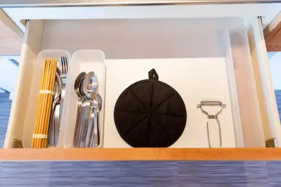 a drawer with silver utensils on a shelf at NEIJU Apartment Hotel - Live Like a Local in Nakano - Direct Shinjuku Access in Tokyo
