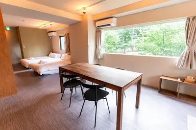 a room with a wooden table and a bedroom at NEIJU Apartment Hotel - Live Like a Local in Nakano - Direct Shinjuku Access in Tokyo
