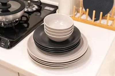 a stack of plates and bowls sitting on a counter at \u5c0f\u718a\u306e\u5bb6 129Ta in Tokyo
