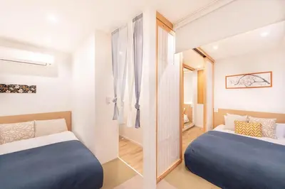a bedroom with two beds and a hallway at \u5c0f\u718a\u306e\u5bb6 129Ta in Tokyo