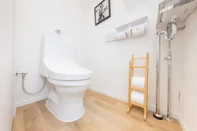 a white toilet in a bathroom with a wooden floor at \u5c0f\u718aAnnex 129Tb in Tokyo