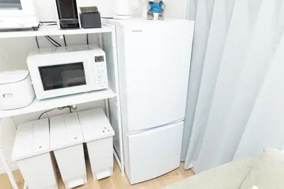 a kitchen with a white refrigerator and a microwave at \u5c0f\u718aAnnex 129Tb in Tokyo