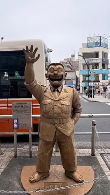 a statue of a man in a costume on a street at \u4e80\u306e\u3084 \u99c5\u5f92\u6b697\u5206 \u7a7a\u6e2fDisney\u76f4\u901a SKAC\u3053\u3061\u4e80\u8a18\u5ff5\u9928 in Tokyo