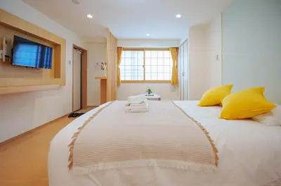 a bedroom with a large white bed with yellow pillows at YYT New listing, 30 seconds walk from the subway, high-speed Wi-Fi, complete facilities, convenient surroundings, high cost performance in Tokyo