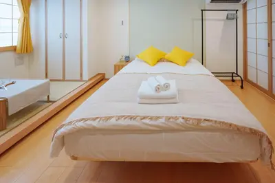 a bedroom with a large white bed with yellow pillows at YYT New listing, 30 seconds walk from the subway, high-speed Wi-Fi, complete facilities, convenient surroundings, high cost performance in Tokyo