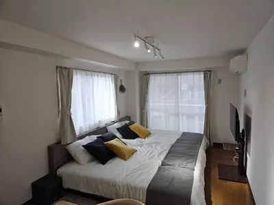 a bedroom with a large bed with yellow pillows at \u30db\u30c6\u30eb\u30ec\u30b9\u30dd\u30ef\u30fc\u30eb303 in Tokyo