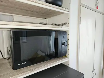 a microwave oven in a cabinet in a kitchen at \u30db\u30c6\u30eb\u30ec\u30b9\u30dd\u30ef\u30fc\u30eb303 in Tokyo