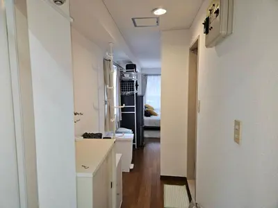 a white kitchen with a hallway leading to a living room at \u30db\u30c6\u30eb\u30ec\u30b9\u30dd\u30ef\u30fc\u30eb303 in Tokyo
