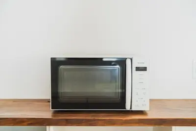 a microwave oven sitting on top of a wooden table at 18min to Disney by Taxi Luxury Mattress 3BR 74 square meter in Tokyo