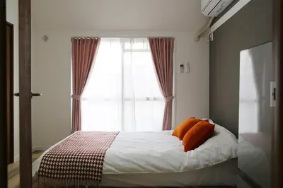 a bed with orange pillows in front of a window at PR54 Winter Tokyo Shinjuku Xmas Lights New Year Shrine in Tokyo