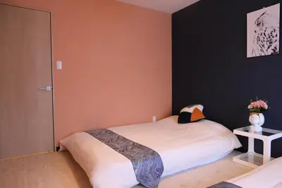 a bedroom with a bed and a vase with flowers at Maple Ginkgo Views Autumn Stay Up To 8 in Tokyo