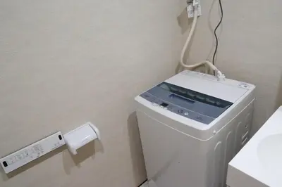 a washing machine in a bathroom with a charger at Maple Ginkgo Views Autumn Stay Up To 8 in Tokyo