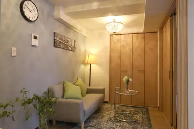 a living room with a couch and a clock on the wall at N202 Ikebukuro Shinjuku Up to 6 guests in Tokyo