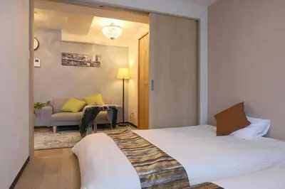 a hotel room with two beds and a couch at N202 Ikebukuro Shinjuku Up to 6 guests in Tokyo