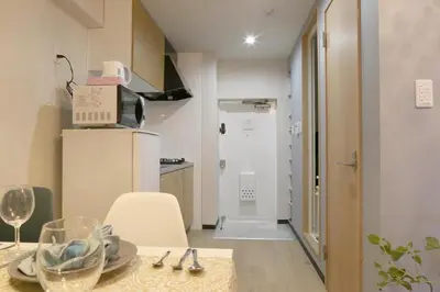 a room with a table and a kitchen with a refrigerator at N202 Ikebukuro Shinjuku Up to 6 guests in Tokyo