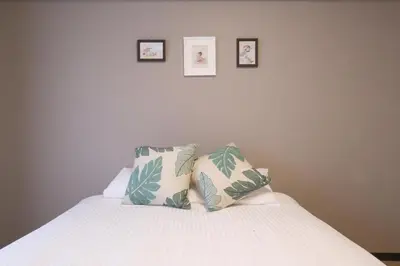 a bed with four pillows on it with three pictures on the wall at N202 Ikebukuro Shinjuku Up to 6 guests in Tokyo