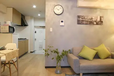 a living room with a couch and a clock on the wall at N202 Ikebukuro Shinjuku Up to 6 guests in Tokyo