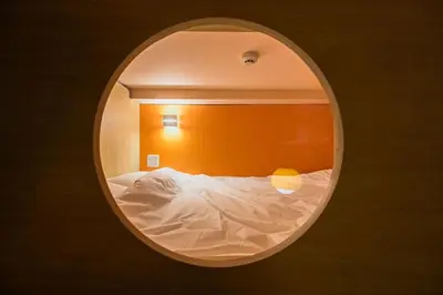 a bedroom with a white bed in a round mirror at 4K Cinema Duplex, 8 Guests, 4 min in Tokyo