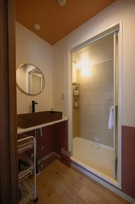 a bathroom with a shower with a sink and a mirror at 4K Cinema Duplex, 8 Guests, 4 min in Tokyo