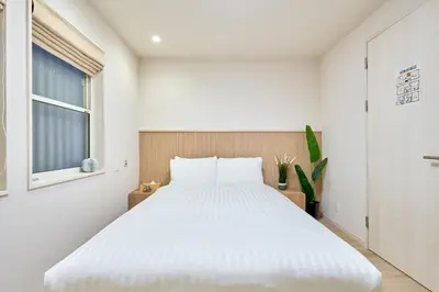 a bedroom with a white bed and a window at STAY ARI Higashishinjuku in Tokyo