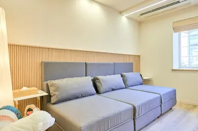 a blue couch in a room with a window at STAY ARI Higashishinjuku in Tokyo