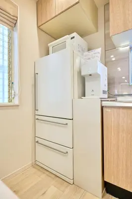a white refrigerator with boxes on top of it in a kitchen at STAY ARI Higashishinjuku in Tokyo