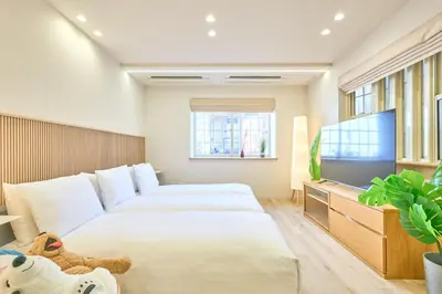 a bedroom with two beds and a flat screen tv at STAY ARI Higashishinjuku in Tokyo