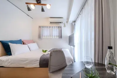 a bedroom with a bed and a table with a table sidx sidx sidx at T-Flat SASAZUKA in Tokyo