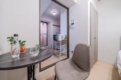 a room with a table and a chair and a mirror at T-Flat SASAZUKA in Tokyo