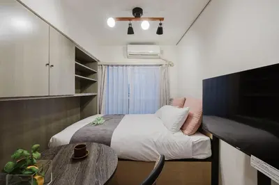 a small bedroom with a bed and a table at T-Flat SASAZUKA in Tokyo