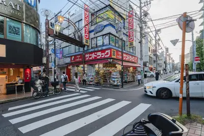 a busy city street with a crosswalk in front of a store at T-Flat SASAZUKA in Tokyo