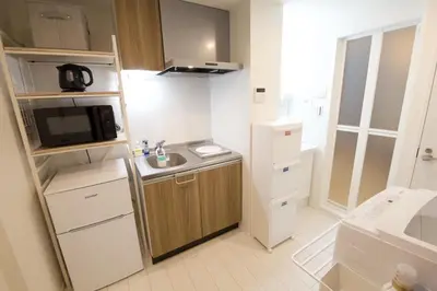 a small kitchen with a sink and a microwave at Kokoon Hotel Ebisu in Tokyo