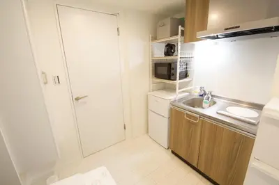 a small kitchen with a sink and a microwave at Kokoon Hotel Ebisu in Tokyo