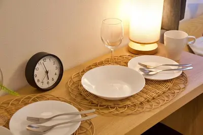 a table with white plates and a clock and a clock at Kokoon Hotel Ebisu in Tokyo