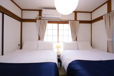 two beds in a room with a window at \u5800\u52074\u4e01\u76ee\u6238\u5efa in Tokyo