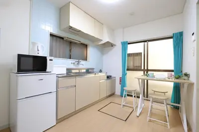 a kitchen with white appliances and a table with chairs at \u5800\u52074\u4e01\u76ee\u6238\u5efa in Tokyo